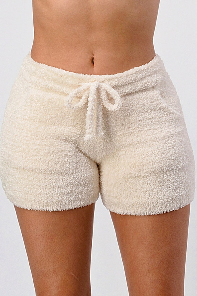 May include: Cream-colored fuzzy shorts with a drawstring waist.