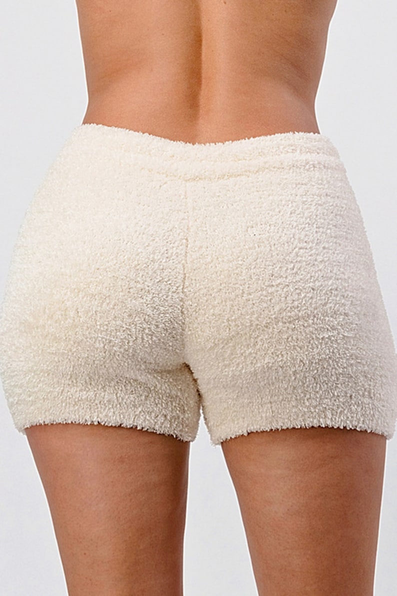 May include: Cream-colored fuzzy shorts with a drawstring waist.
