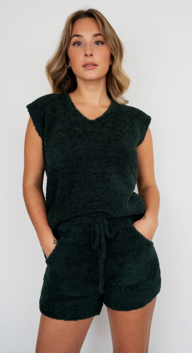 May include: A dark green fuzzy sleeveless top and matching shorts set. The top has a v-neck and the shorts have a drawstring waist.