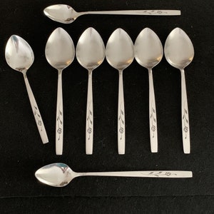 May include: Set of eight silver teaspoons with a floral design. The spoons have a simple, elegant design and are perfect for everyday use.