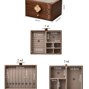 May include: A wooden jewelry box with a clear glass top and a gold-colored clover-shaped handle. The box is 10.2 inches long, 7.7 inches wide, and 5.9 inches tall. The interior has multiple compartments and drawers for organizing jewelry.