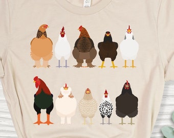 Puede incluir: Una camiseta beige con un gráfico de diez pollos en fila. Los pollos son de diferentes colores y razas.
