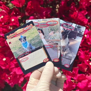 May include: Three black and white trading cards with a white background and black text. The cards feature images of dogs and the text "Card Name", "Token Name", "Card Type - Subtype", "Rules Text", and "2/1", "2/2", and "1/1".