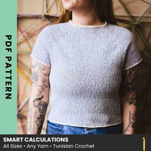 May include: A short-sleeved, light purple, textured knit top with a round neckline and cream-colored trim. The text on the image reads: PDF PATTERN, SMART CALCULATIONS, All Sizes • Any Yarn • Tunisian Crochet.