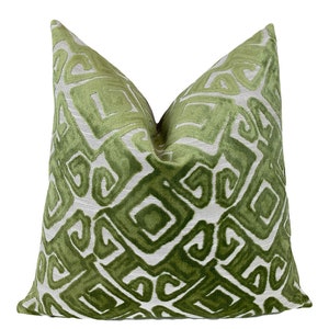 May include: Green and white geometric patterned throw pillow with a velvet texture.