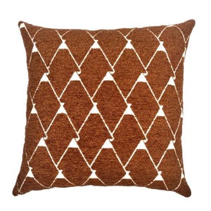 May include: A square throw pillow featuring a textured, burnt orange fabric surface. The pillow is decorated with a repeating geometric pattern of white diamond shapes that are connected by thin white lines across the entire front face.