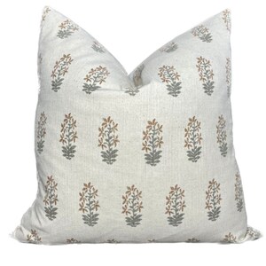 May include: A white pillow cover with a repeating pattern of gray and brown floral designs.