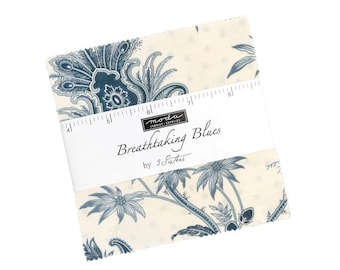 May include: A stack of square fabric pieces featuring a cream background with blue floral and paisley patterns. A white paper band wraps around the center, displaying the text "moda FABRICS + SUPPLIES Breathtaking Blues by 3 Sisters" and a ruler.