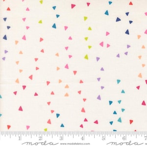 May include: A cream-colored fabric featuring a scattered pattern of small, multi-colored triangles in shades of pink, blue, orange, purple, and lime green. A ruler at the bottom shows measurements in inches, with the text moda and modafabrics.com.
