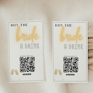 Könnte beinhalten: Zwei weiße Karten mit schwarzem Text, der "Kaufe der Braut einen Drink" lautet, mit einem QR-Code und dem Text "@BRIDE123" und "venmo".