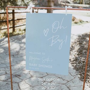 May include: A light blue baby shower sign with white text that reads "Welcome to [Name]'s Baby Shower" and "Oh Boy!" with a heart. The sign also lists different size options for the sign in inches.