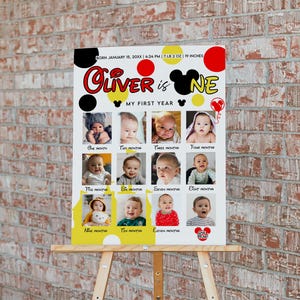 May include: A personalised photo collage on a white background, displayed on a wooden easel. The collage features a child's photos from one to eleven months, with the name "Oliver" and the phrase "My First Year" in a playful font. The top includes birth details.