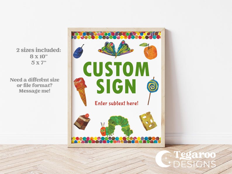 Peut inclure: Une affiche encadr&eacute;e personnalis&eacute;e avec des illustrations color&eacute;es d'aliments et un papillon. L'affiche comprend le texte "CUSTOM SIGN" en vert, avec un espace pour un sous-texte. Le cadre est de couleur claire, sur fond blanc.