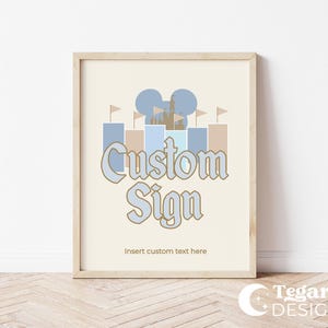 Puede incluir: Un cartel imprimible con una silueta de castillo azul claro y beige, una cabeza de Mickey Mouse y el texto "Custom Sign" con las palabras "Insert custom text here" debajo.