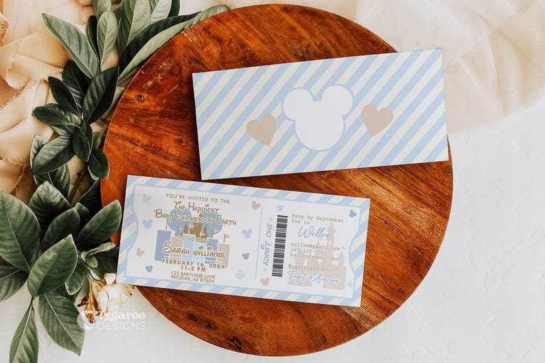 Puede incluir: Dos invitaciones para baby shower con tem&aacute;tica de Disney. Una invitaci&oacute;n es un dise&ntilde;o de boleto con detalles del evento. La otra es una tarjeta a rayas azules y blancas con una silueta de Mickey Mouse y corazones.