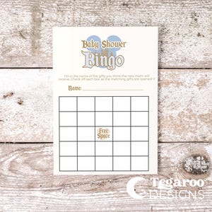 May include: A cream-colored Baby Shower Bingo card with blue and gold text and graphics. The card has a grid for game play and includes the text "Free Space". The Tegaroo Designs logo is at the bottom.