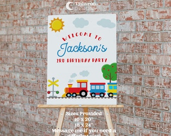 Puede incluir: Señal de bienvenida a la fiesta de cumpleaños número 3 de Jackson con temática de tren. La señal presenta un tren rojo, amarillo y azul con un sol, nubes y un árbol en el fondo. La señal está disponible en dos tamaños: 16 x 20 pulgadas y 18 x 24 pulgadas.