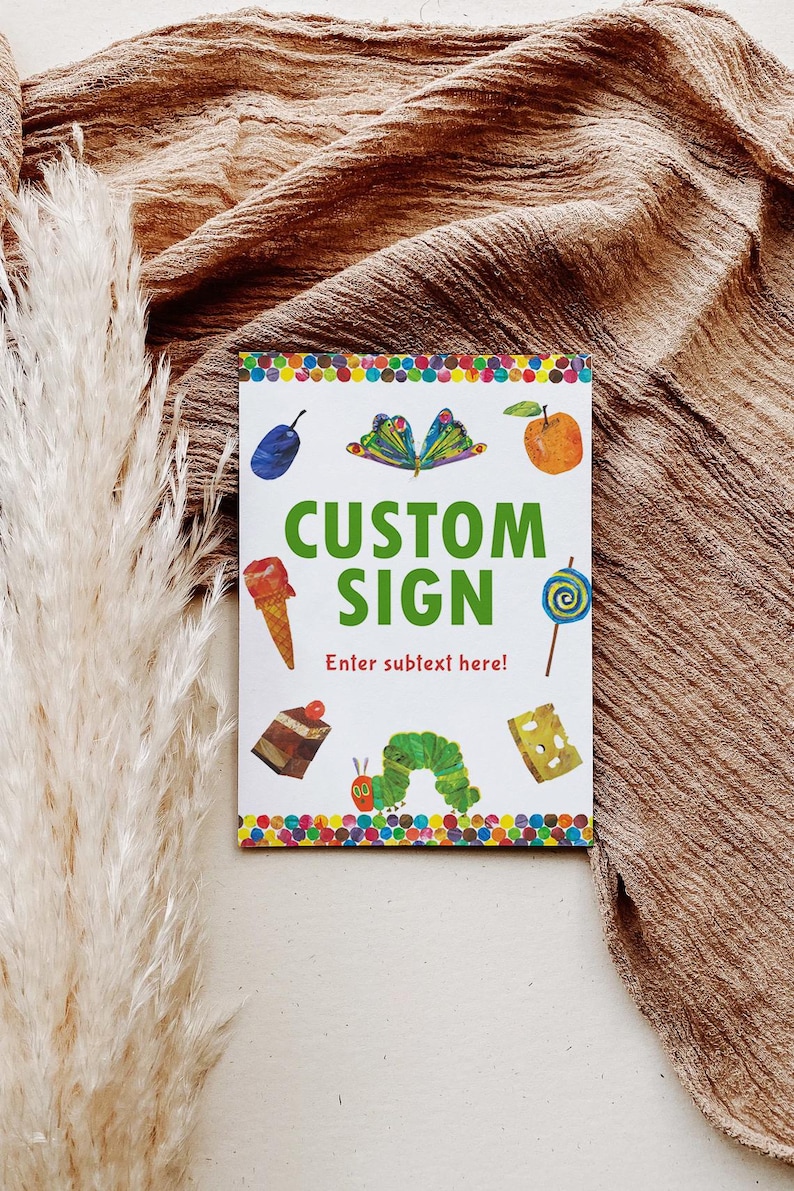 Peut inclure: Une pancarte blanche avec des illustrations color&eacute;es d'aliments et un papillon. Les mots "CUSTOM SIGN" sont en vert, avec "Enter subtext here!" en dessous. La pancarte est sur une surface marron textur&eacute;e.