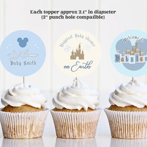 May include: Three cupcakes topped with round toppers for a baby shower. The toppers are approximately 2.1 inches in diameter. One topper says "Welcome Baby Smith", another says "Happiest Baby shower on Earth", and the last says "Welcome to Babyland".