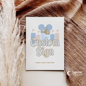 Może przedstawiać: Biała kartka z złotym obramowaniem głowy Myszki Miki i zamku. Tekst "Custom Sign" jest złotymi literami. Tekst "Insert custom text here" znajduje się pod znakiem.
