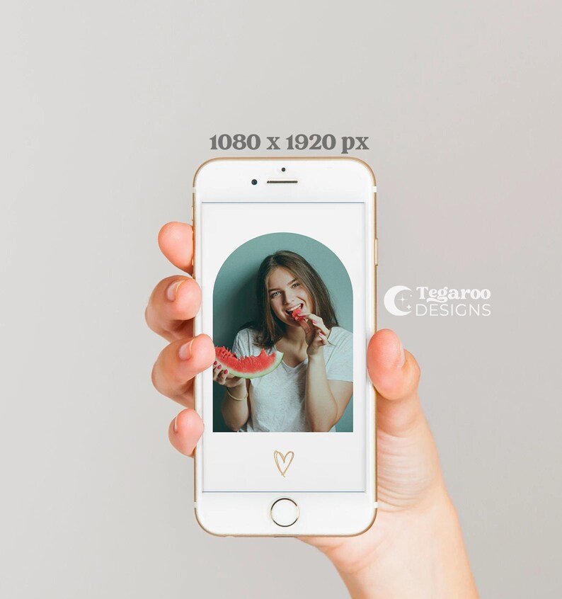May include: A woman smiles while holding a slice of watermelon in front of a phone screen. The phone screen shows a photo of the woman with a watermelon, a heart, and the text "Tegaroo Designs".