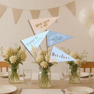May include: A baby shower table setting with floral arrangements in mason jars. Triangle pennants with text like "Wish upon a star" and "Happiest Baby shower on Earth" are displayed. White balloons and a banner are in the background.