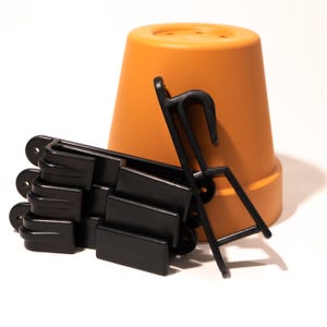 Op de afbeelding: Een set zwarte plastic plantenpot ophangers met een terracotta pot.