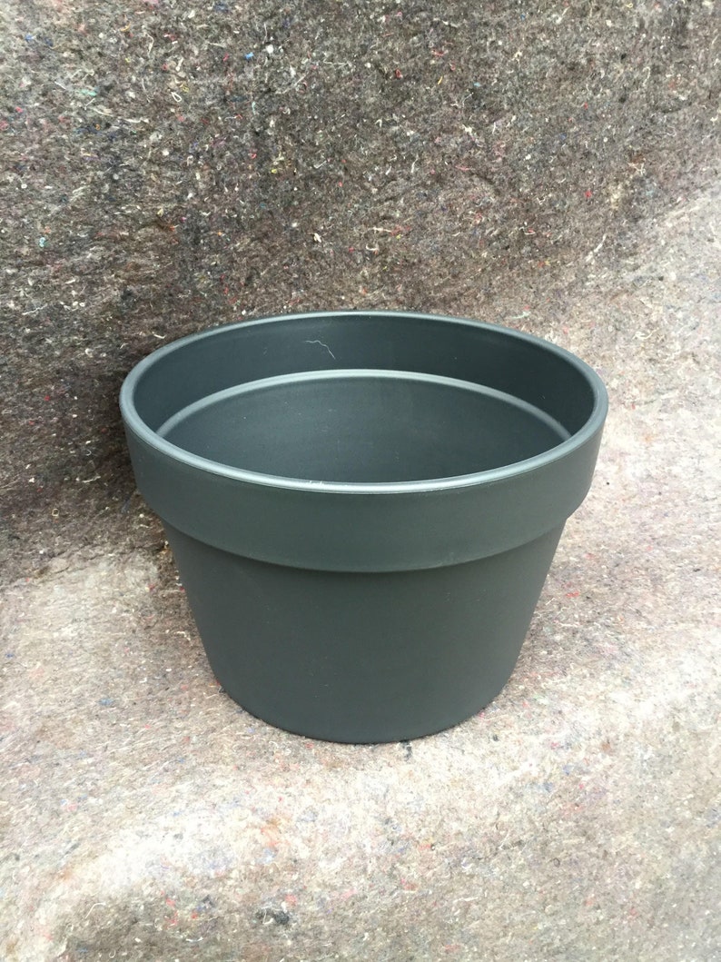 May include: A dark gray plastic plant pot with a wide rim.