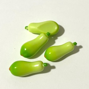 Peut inclure: Quatre figurines miniatures de papayes vertes et jaunes. Les papayes sont en plastique et ont une finition lisse et brillante.