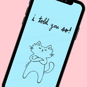 Op de afbeelding: Een smartphone toont een lichtblauw scherm met een zwarte omtrek tekening van een kat met gekruiste armen en de tekst "i told you so!". De telefoon staat tegen een roze achtergrond.