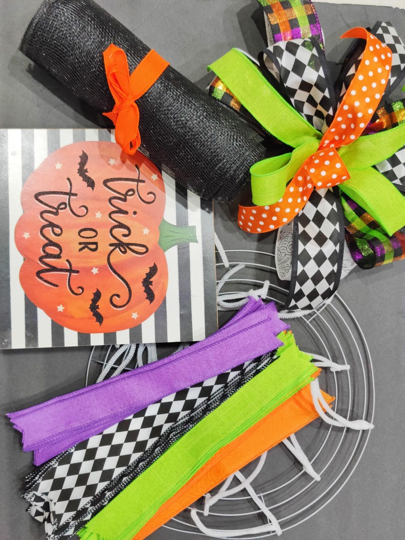 May include: Halloween wreath making kit with black mesh, orange and white polka dot ribbon, black and white checkered ribbon, green ribbon, purple, green, orange and black and white checkered ribbon, a metal wreath form, and a sign that says "Trick or Treat".