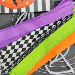 May include: A set of Halloween craft supplies including purple, green, and orange ribbon, black and white checkered ribbon, and white pipe cleaners.