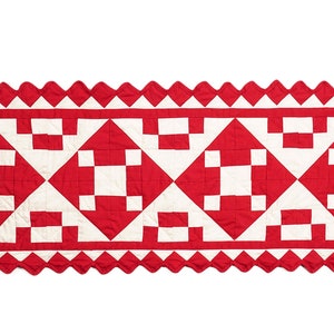 May include: A red and white patchwork quilt runner with a scalloped edge. The runner features a repeating pattern of squares and diamonds.