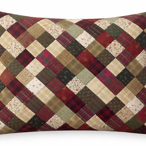 May include: Rectangular pillow with a patchwork design. The pillow features a variety of fabrics in shades of red, green, beige, and cream, arranged in a diagonal grid pattern. The fabrics include floral prints, plaid, and solid colors.