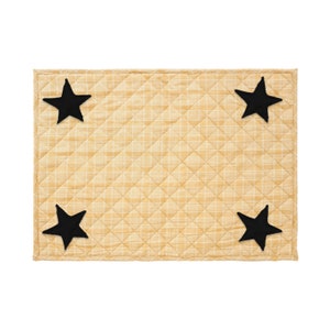 May include: A yellow quilted placemat with four black felt stars.