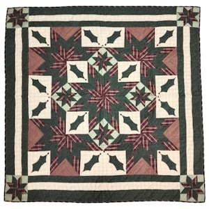 May include: A square quilt with a festive design. The quilt features a central pattern of green and burgundy plaid stars, surrounded by white and green holly leaf motifs. The border is a dark green with a white stripe.