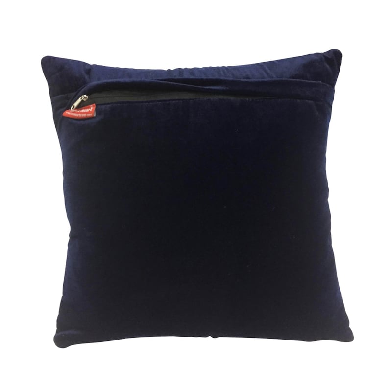 May include: A dark blue velvet pillow with a zipper closure on the back. The zipper pull is red.
