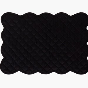 Pode incluir: Tapete de mesa acolchoado preto com borda festonada.