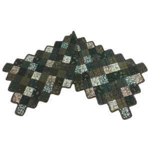 May include: A green and brown patchwork quilted tree skirt with a scalloped edge.