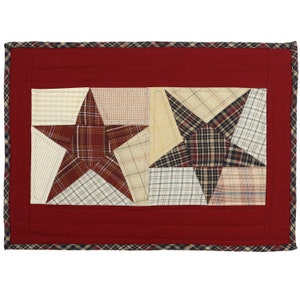 Può includere: Tovaglietta all'americana trapuntata rossa con un design patchwork che presenta due grandi stelle realizzate in tessuto a quadri in tonalità di marrone, beige e nero.