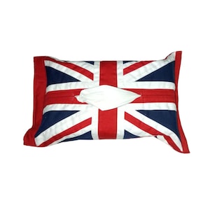 May include: A rectangular tissue box cover featuring the Union Jack flag design. The cover is primarily red, white, and navy blue, with a white tissue emerging from the center. The edges are red, and the overall design is a patriotic theme.