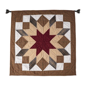May include: A brown, tan, and white patchwork quilt with a large red star in the center. The quilt has a brown border and is decorated with tassels.