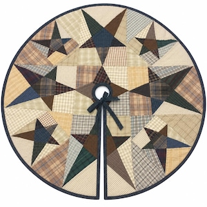May include: A circular fabric tree skirt featuring a patchwork design of various plaid and checkered patterns in shades of navy blue, brown, tan, and cream. The design includes multiple star shapes and a center opening with fabric ties.