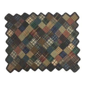 Op de afbeelding: Een patchworkdeken met een bruin, groen en blauw ruitpatroon. De deken heeft een gegolfde rand en is gemaakt van verschillende stoffen.