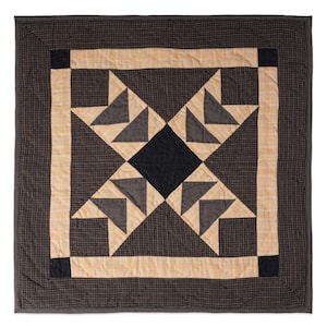 May include: A black and tan quilt with a star pattern in the center. The quilt is made of squares and triangles.