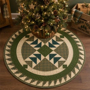 Puede incluir: Una falda redonda para árbol de Navidad con un diseño geométrico. La falda presenta un patrón central de triángulos y cuadrados verdes y turquesa, rodeado por un borde verde con triángulos crema. Se coloca debajo de un árbol de Navidad decorado.