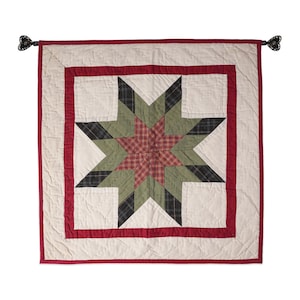 May include: A red, green, and black patchwork quilt with a star design. The quilt is framed with a red border and has a white background.