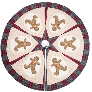 Puede incluir: Una falda de árbol de Navidad de cuadros beige y rojo con seis aplicaciones de hombre de jengibre. La falda tiene un centro en forma de estrella y un cierre de corbata.