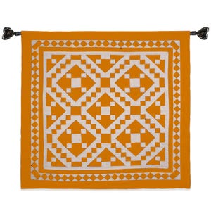 Peut inclure: Une tenture murale carrée orange avec un motif géométrique blanc. Le motif présente des formes de losanges et de carrés. La tenture est suspendue par deux embouts décoratifs noirs en forme de cœur.
