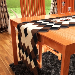 May include: A brown, black, and white checkered table runner with a wavy edge. The runner is on a wooden table with two chairs.